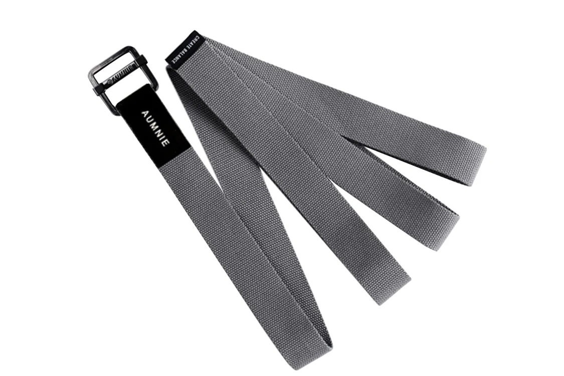 An AUMNIE grey yoga strap with a buckle, the kind you loop around the feet in a seated forward fold.